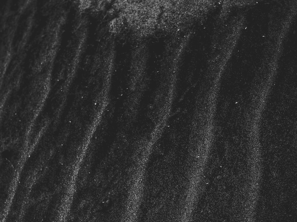 a black and white photo of sand and water