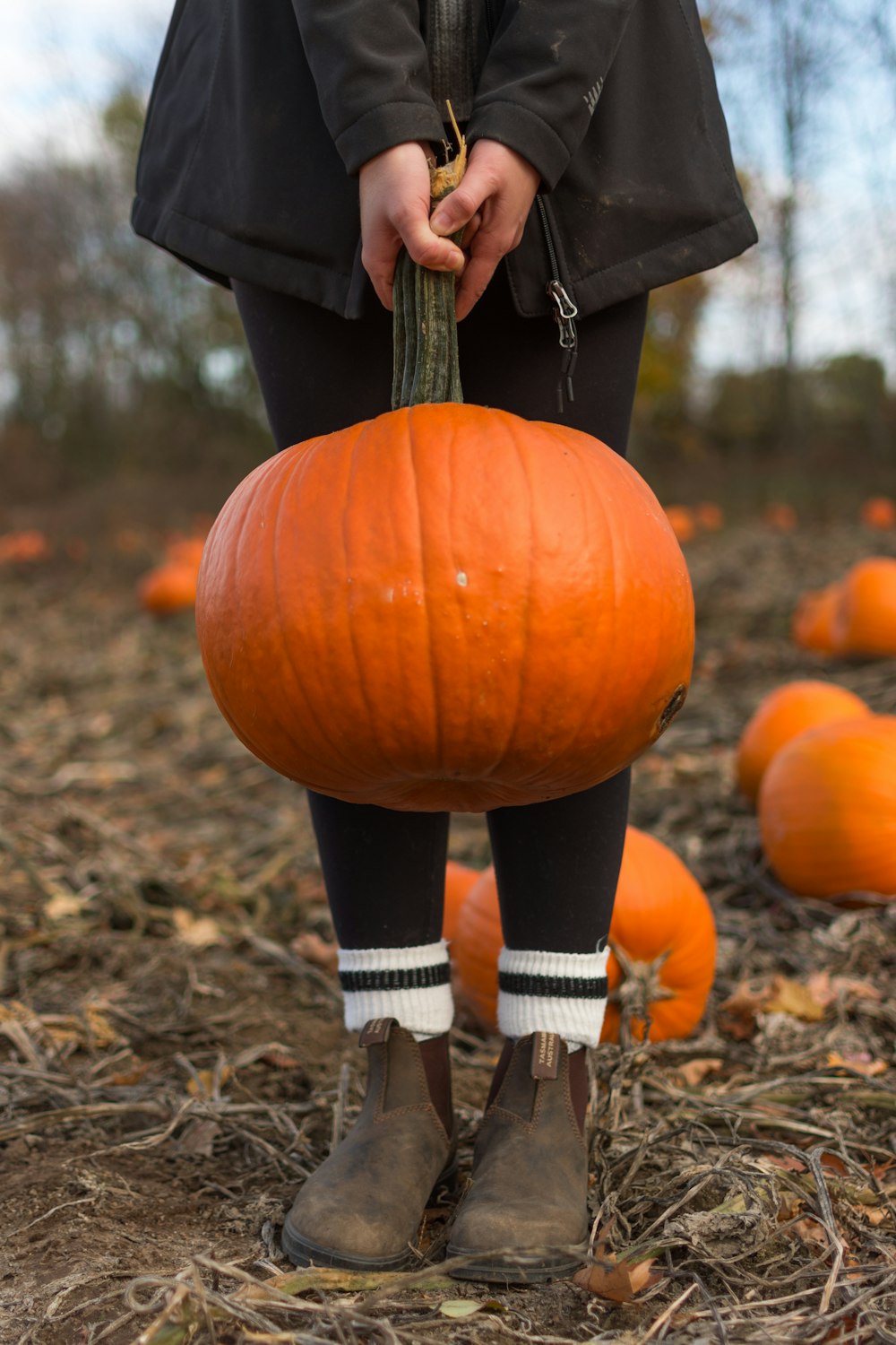 child carrying orange pumpkin