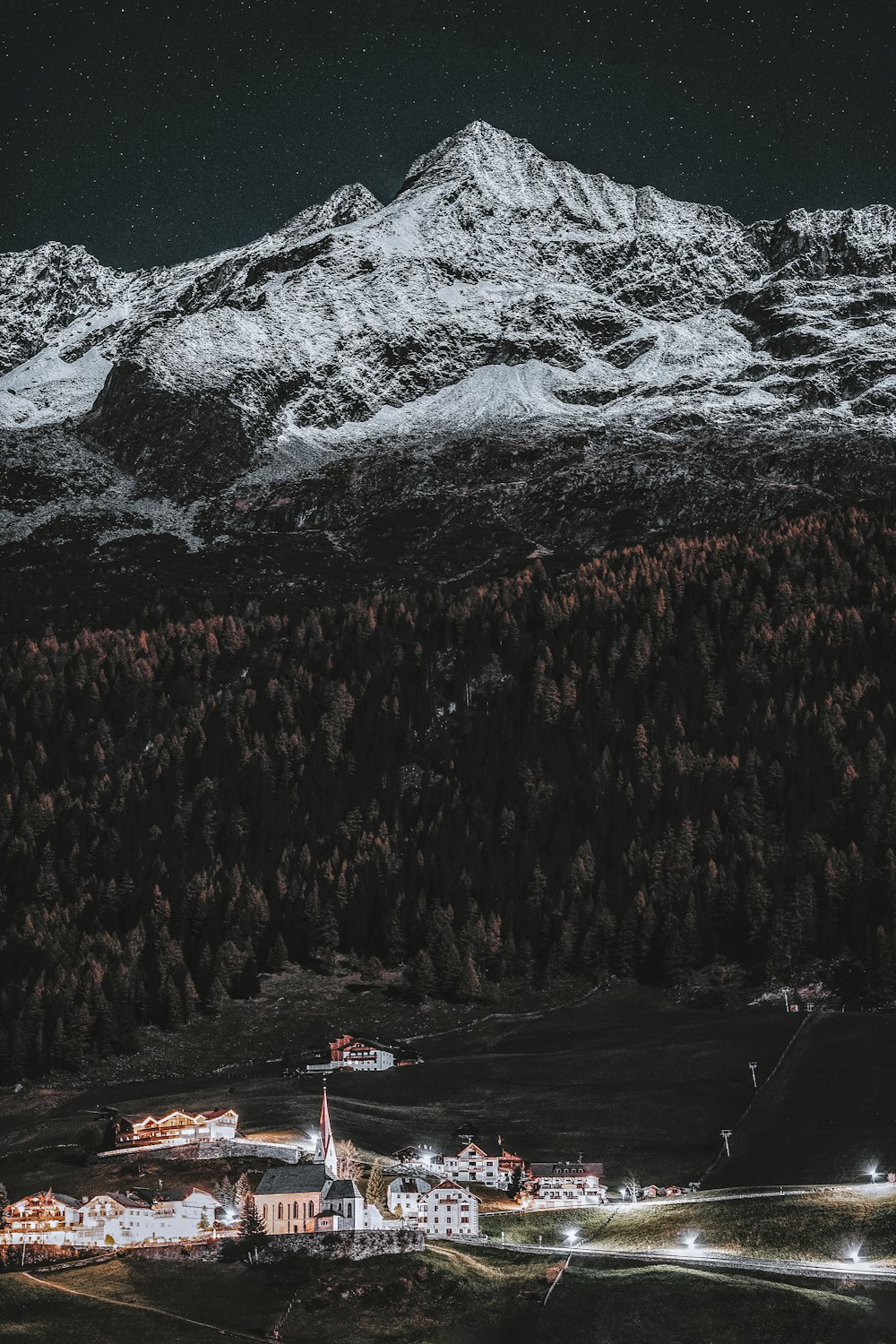 montanha coberta de neve perto da aldeia durante o dia