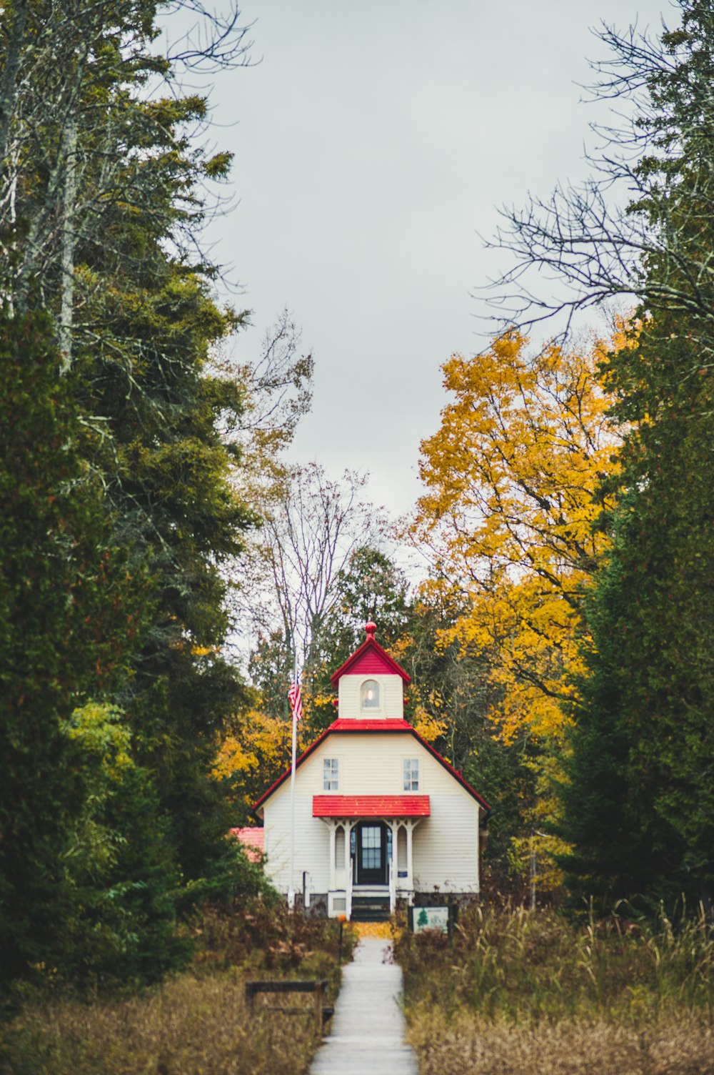 white and red house surrounded by trees