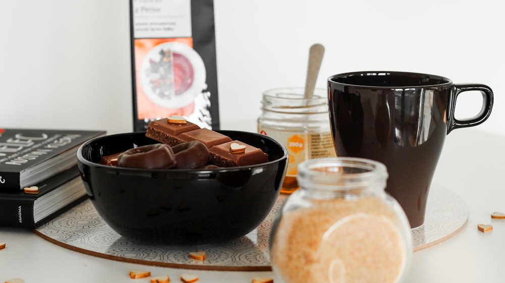 black ceramic mug beside ceramic bowl