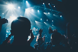 Crowded metalhead fans raising fists at a nighttime outdoor concert.