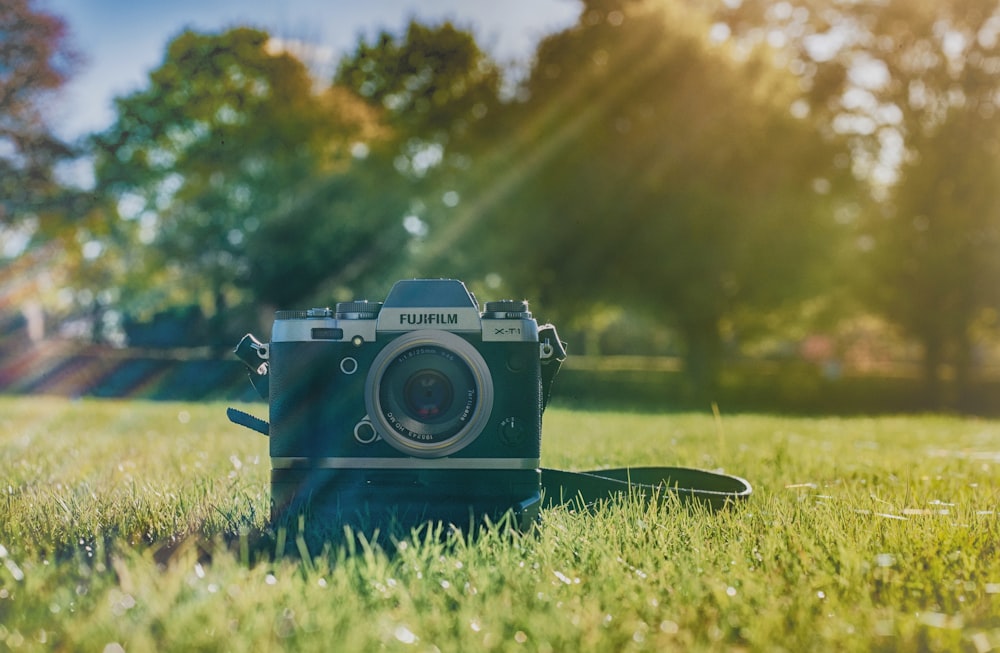 câmera Fujifilm preta no campo de grama