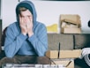 man covering face with both hands while sitting on bench