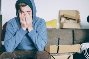 man covering face with both hands while sitting on bench