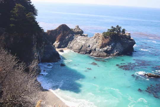 calm body of water near cliff in Julia Pfeiffer Burns State Park United States