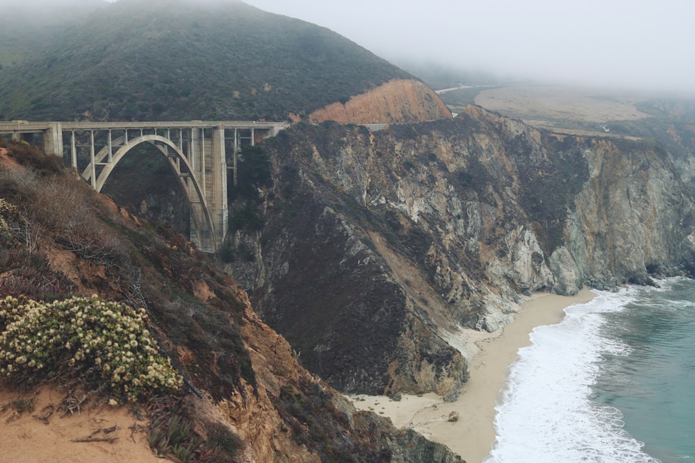 gray and brown bridge beside beach during daytime