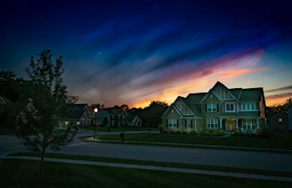 A vigilant security professional monitoring a residential neighborhood at dusk.