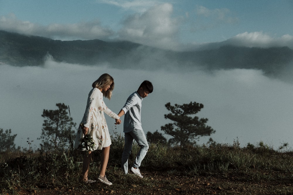 man and woman walking while holding hands