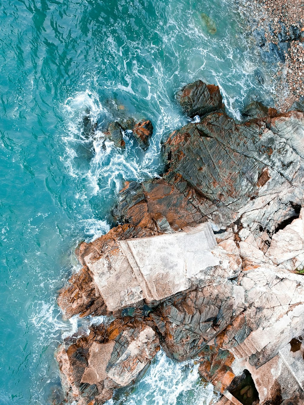 high-angle photography of body of water near rock formation