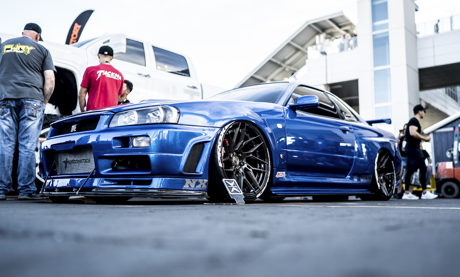 Sony a7S II + Sony Distagon T* FE 35mm F1.4 ZA sample photo. Parked blue coupe beside photography