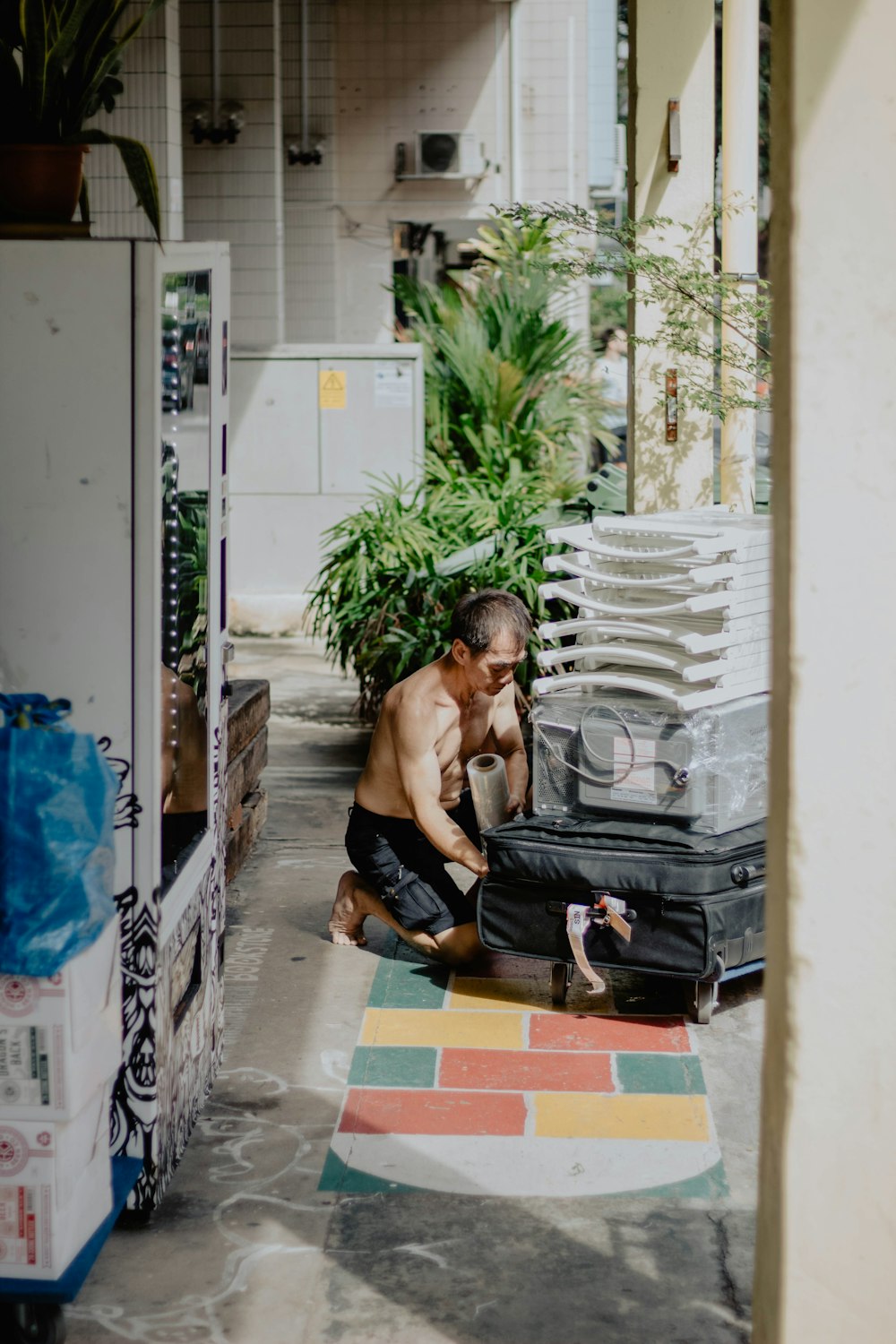 Homme agenouillé devant des récipients rectangulaires blancs et gris