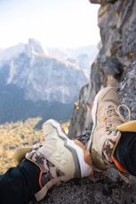person sitting on rock near gray fault-block mountain