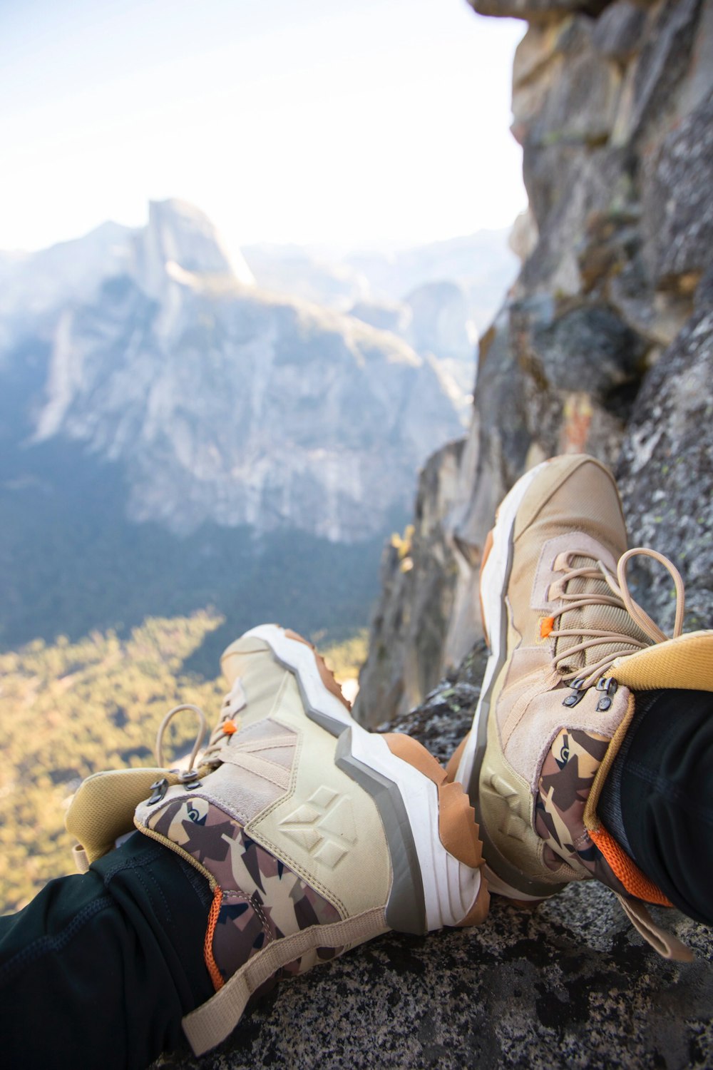 person sitting on rock near gray fault-block mountain