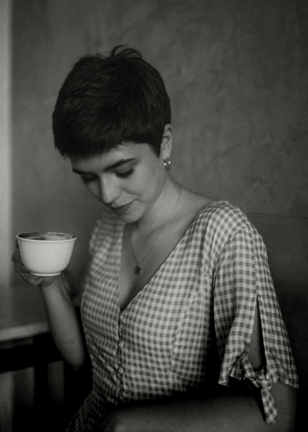 grayscale photography of woman holding cup