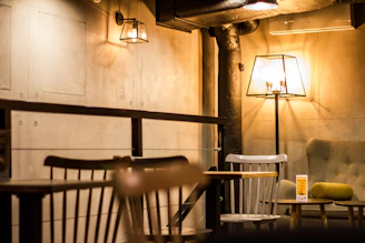 A cozy, dimly lit café interior with dark wood accents and glowing AI-themed art on the walls.