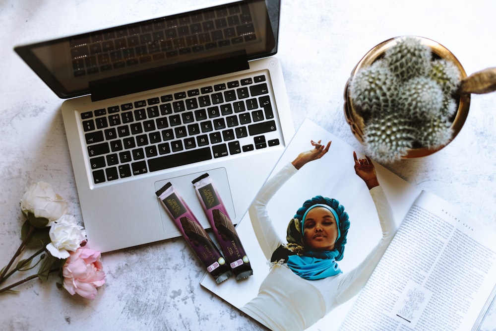 flat-lay photography of cactus plant beside MacBook Pro