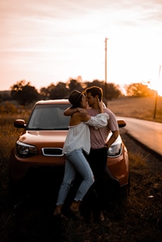 woman and man standing in front of vehicle