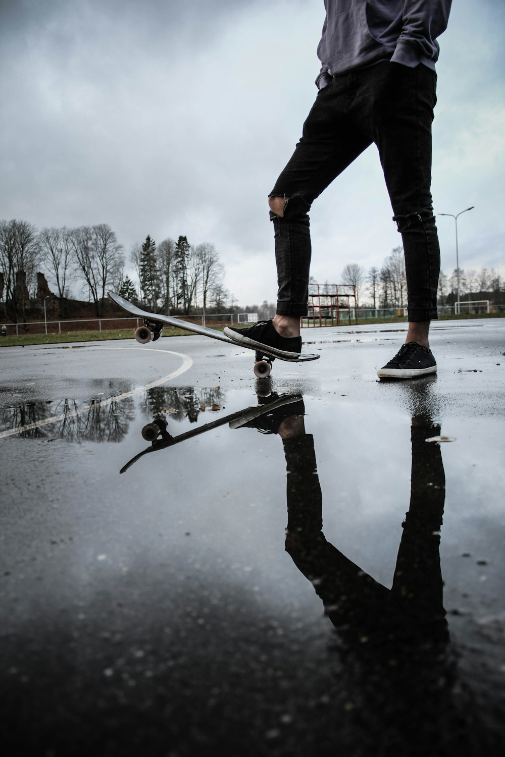 Person in schwarzer Hose, die auf Skateboard tritt