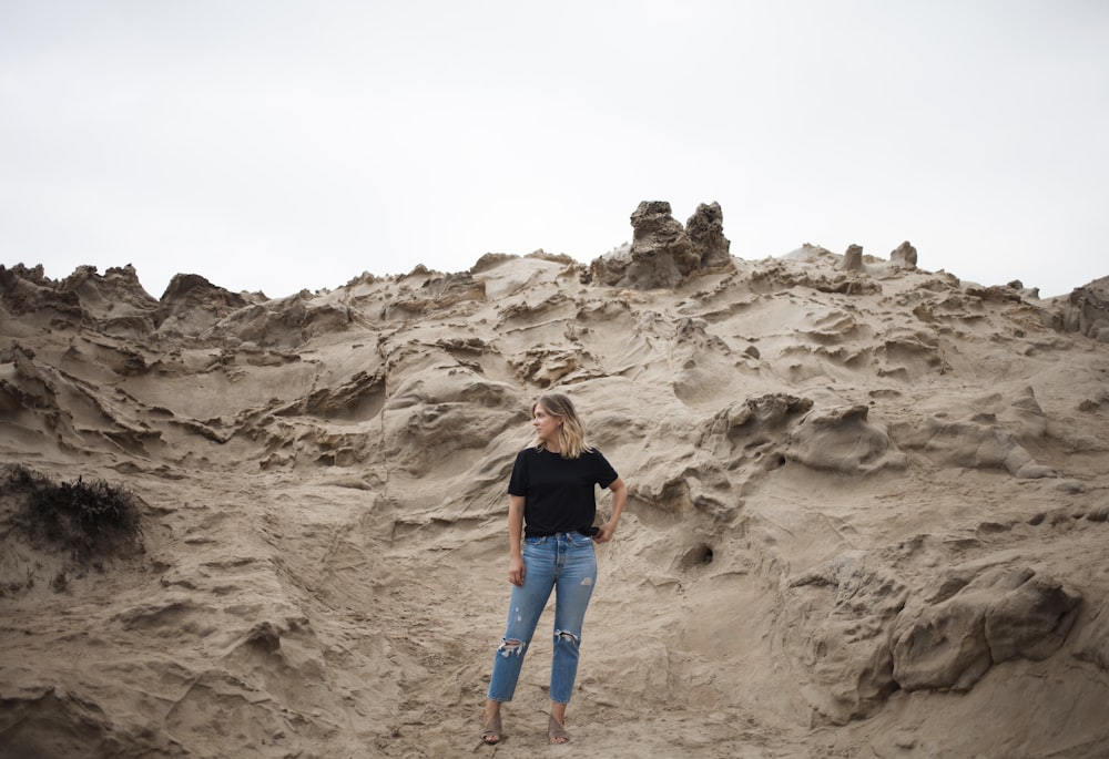 woman in black T-shirt standing on beige mountain