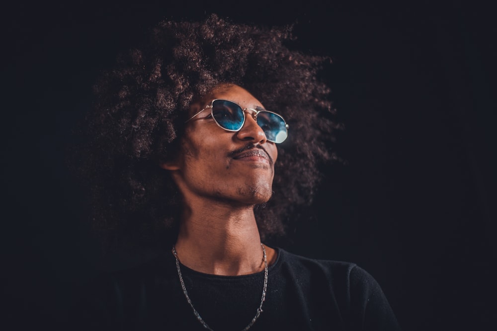 man in black shirt wearing sunglasses and smiling