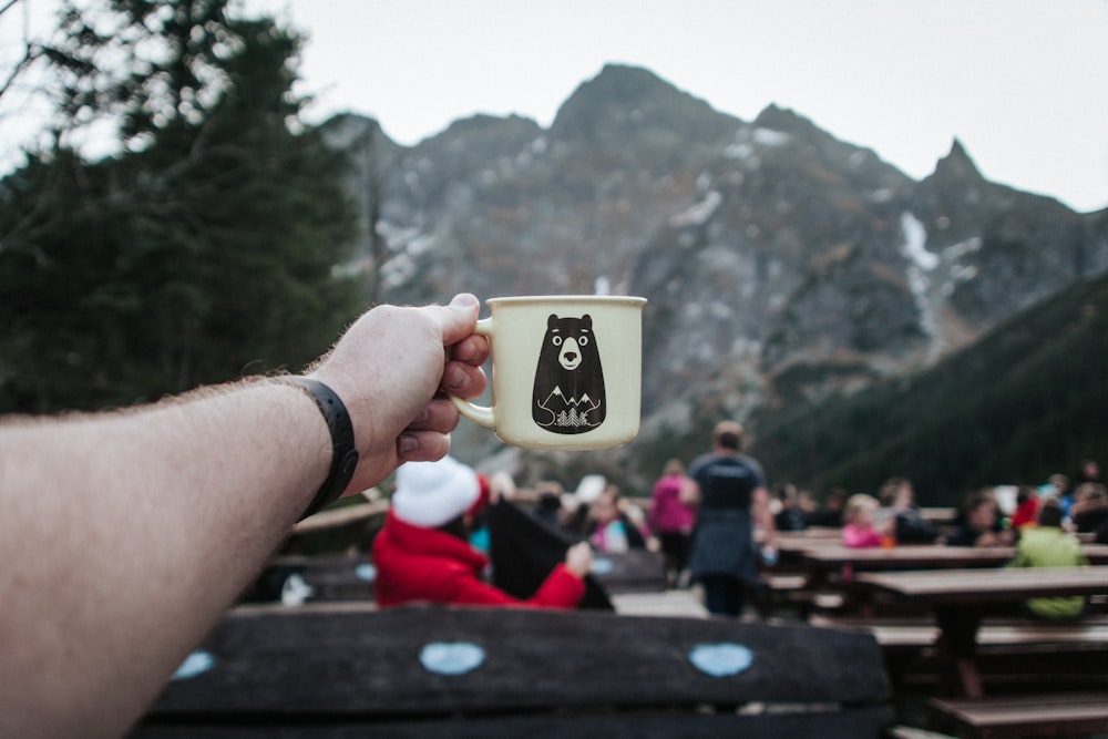 person holding white mug