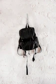 black leather backpack on wall