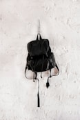 black leather backpack on wall