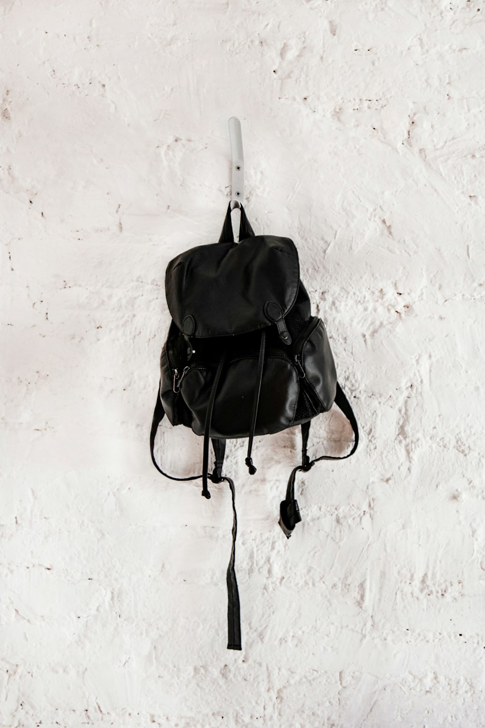 schwarzer Lederrucksack an der Wand