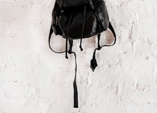 black leather backpack on wall