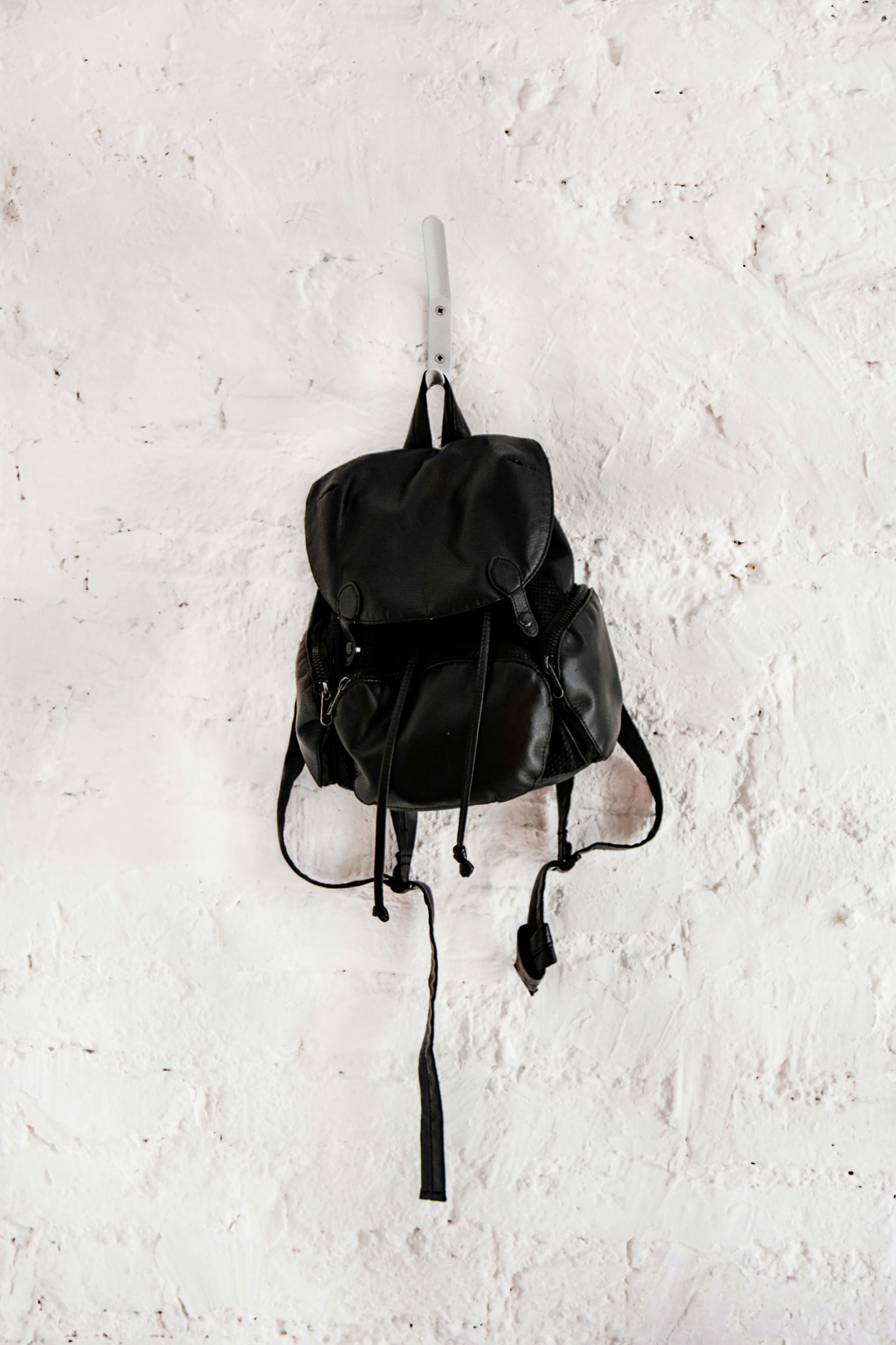 black leather backpack on wall