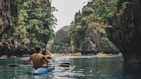 a man and a woman in a kayak on a river