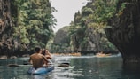 Guests enjoying a peaceful kayak trip among towering cliffs.