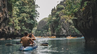 Young adventurers kayaking through crystal-clear fjord waters surrounded by towering cliffs.