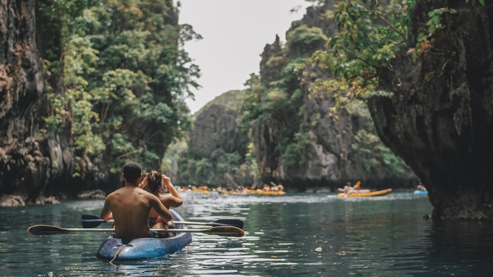 a man and a woman in a kayak on a river