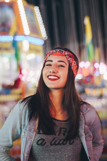 selective focus photography of smiling woman wearing red and black bandana