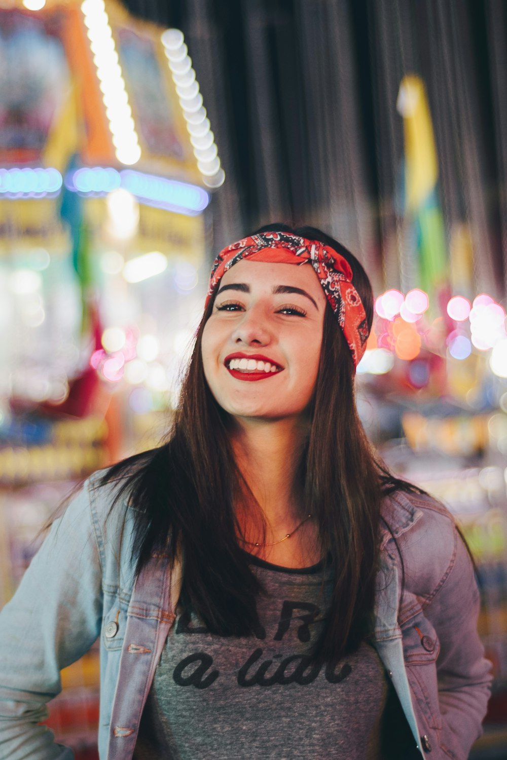 fotografía de enfoque selectivo de mujer sonriente con pañuelo rojo y negro