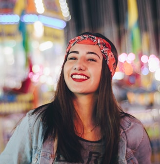 selective focus photography of smiling woman wearing red and black bandana