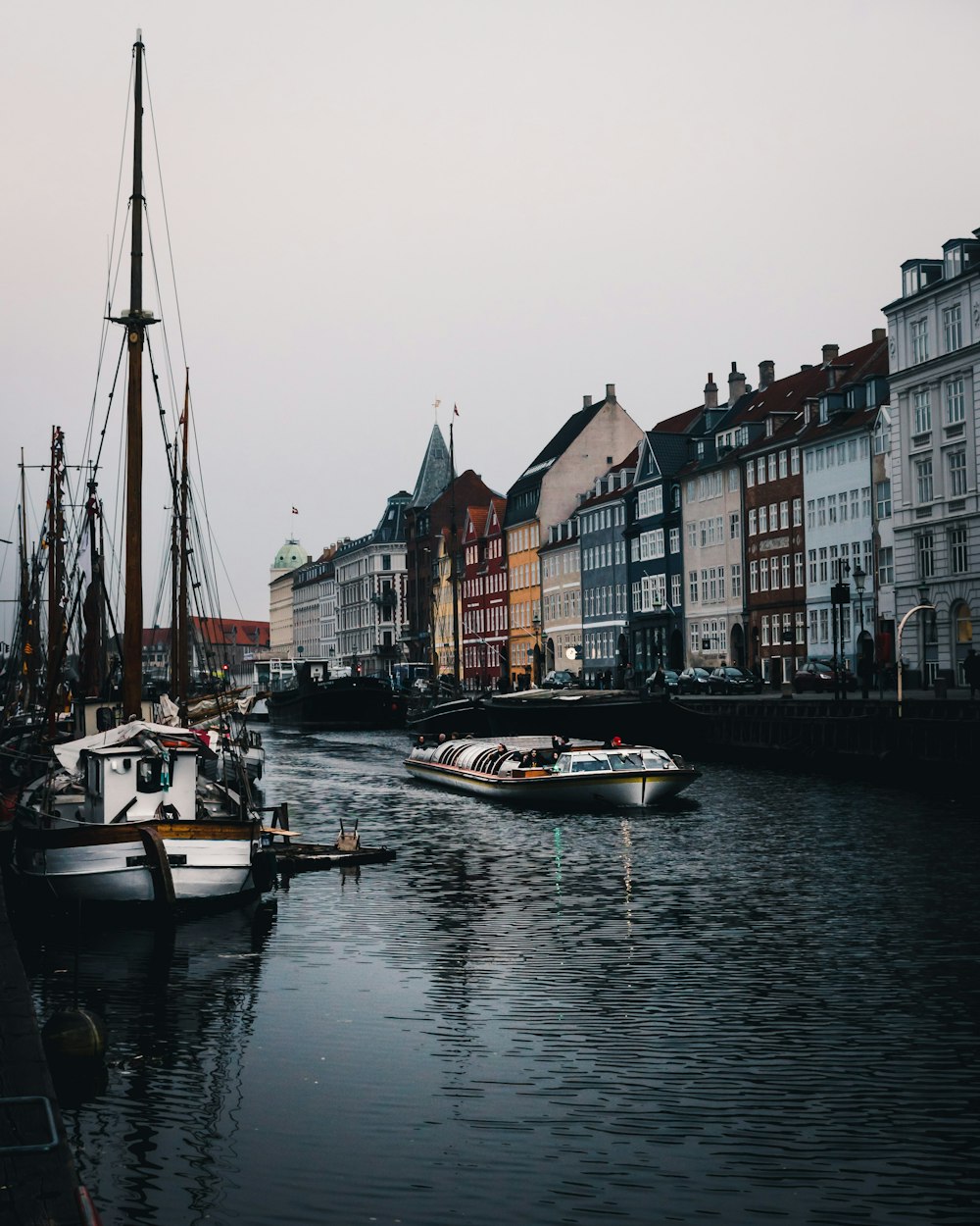 boats on body of water near high rise concrete buildings