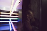 An asymmetric grid layout featuring a cinematic still from a recent video shoot with deep shadows and neon accents.