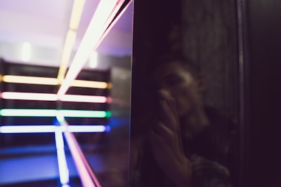 An asymmetric grid layout featuring a cinematic still from a recent video shoot with deep shadows and neon accents.