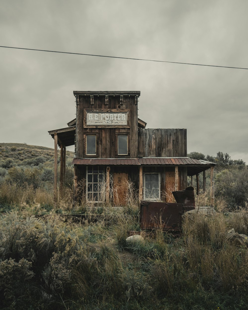 an old run down building sitting in the middle of a field