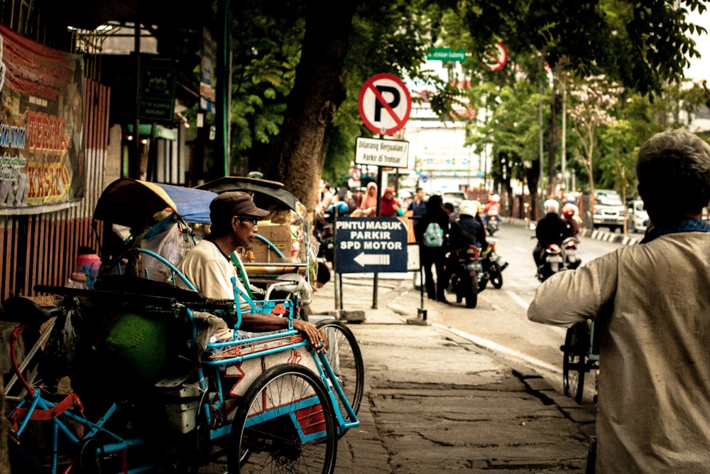 man sitting on motorcycle beside road