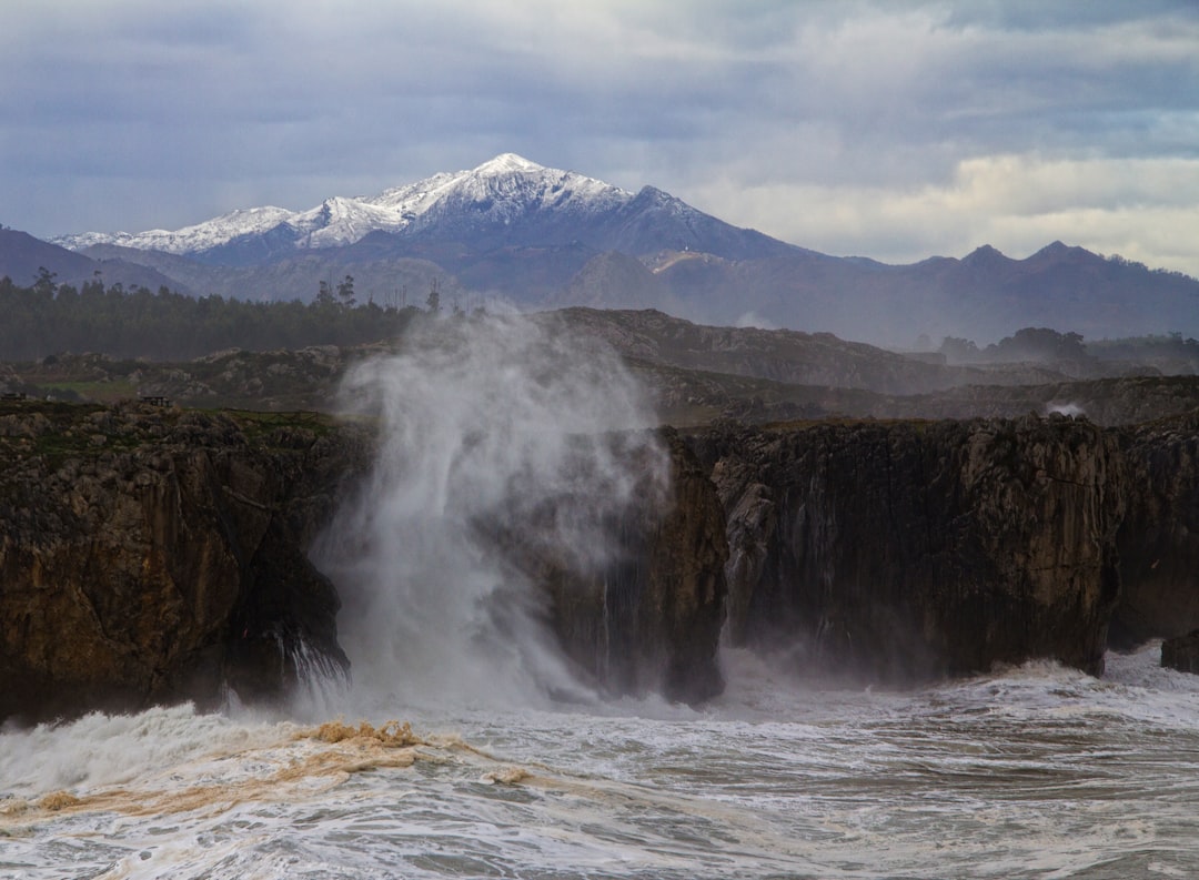 body of water near mountain at daytime