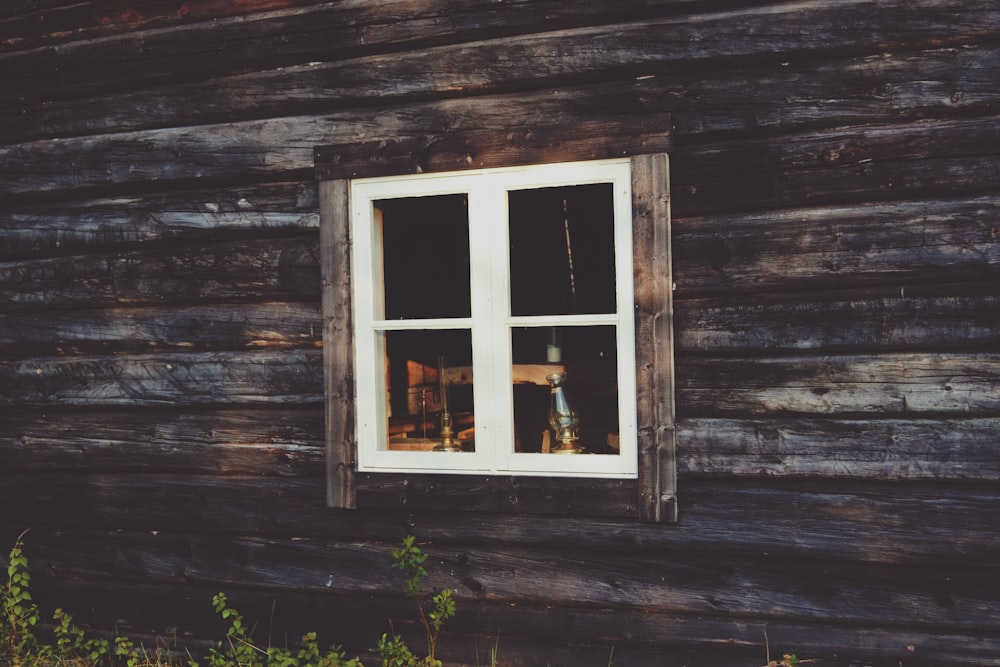 a wooden house with a white window and white trim