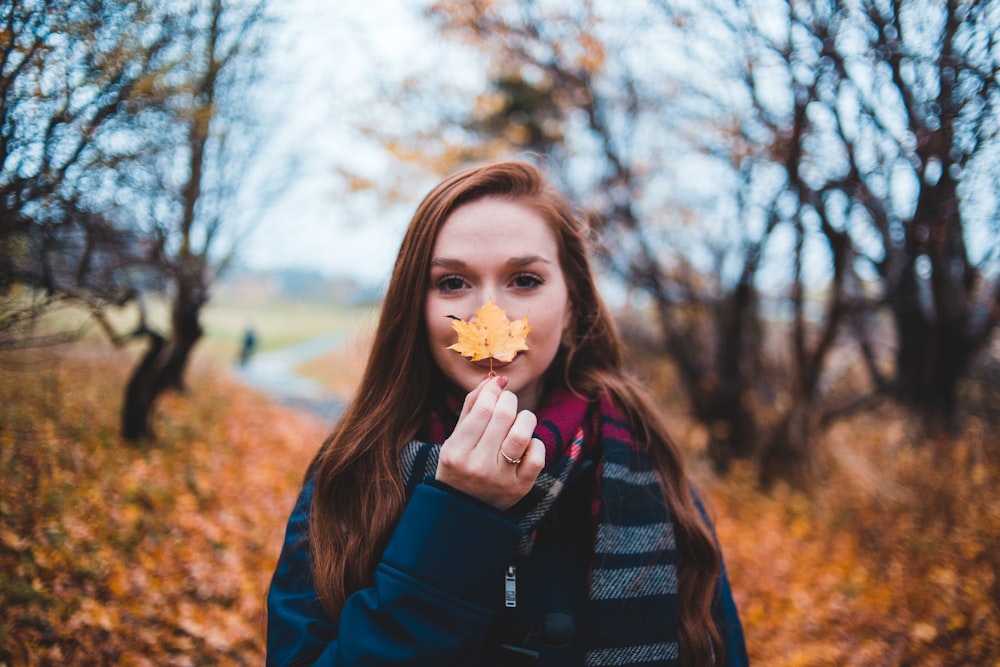 a woman holding a leaf in her hands