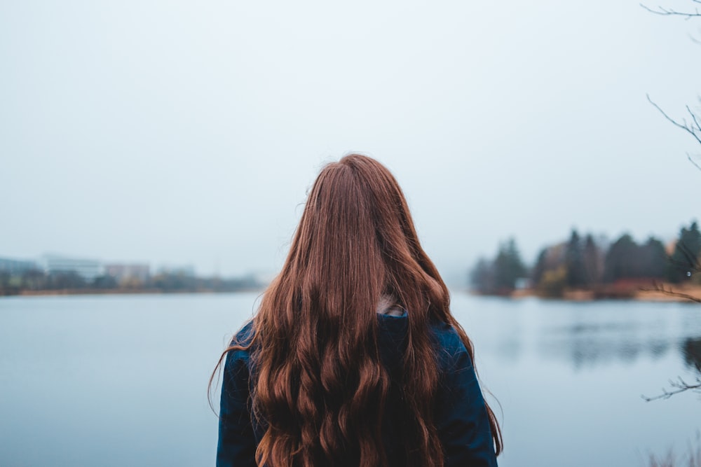 woman looking at blue body of water