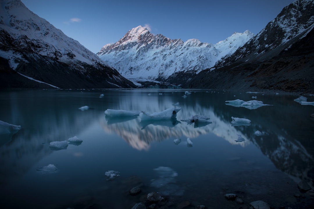 snow capped mountain near body of water during daytime