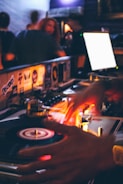 A vibrant DJ spinning vinyl records under colorful stage lights.