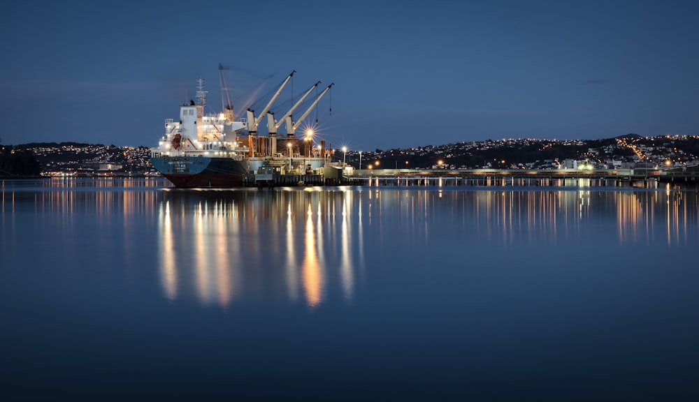 Weiß-blaues Frachtschiff in der Nähe des Docks unter blauem Himmel